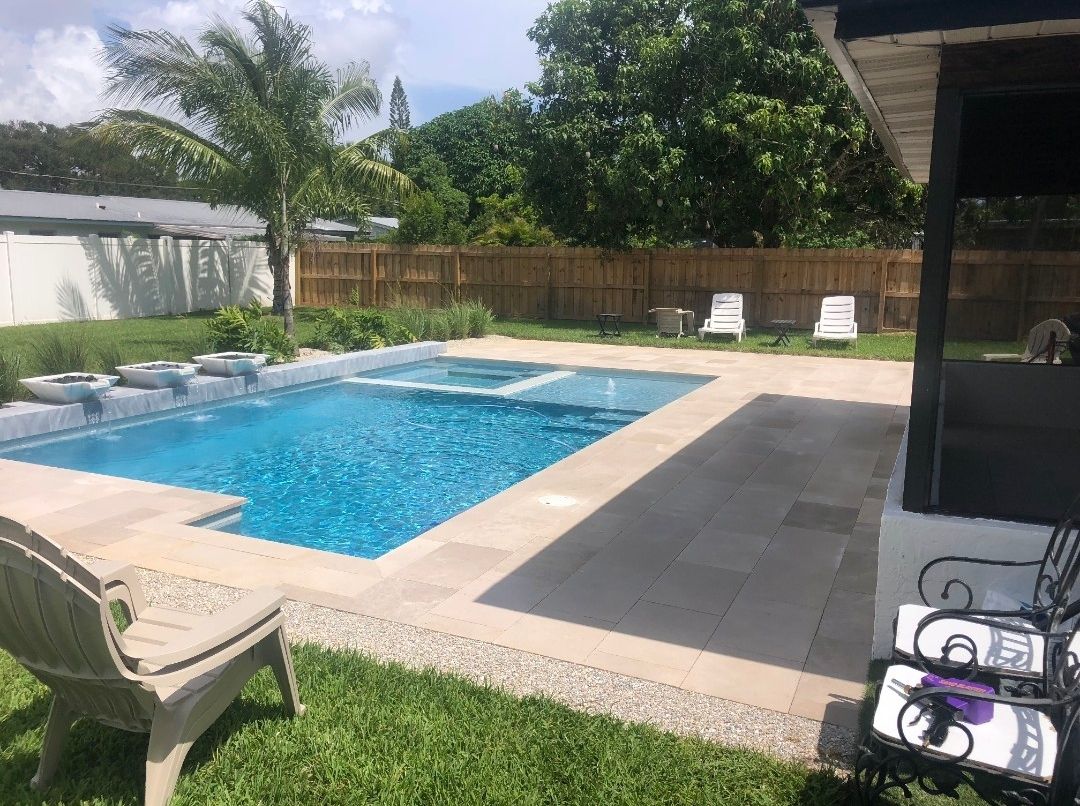 In-ground pool with a raised spa, water bowls, and a paver deck